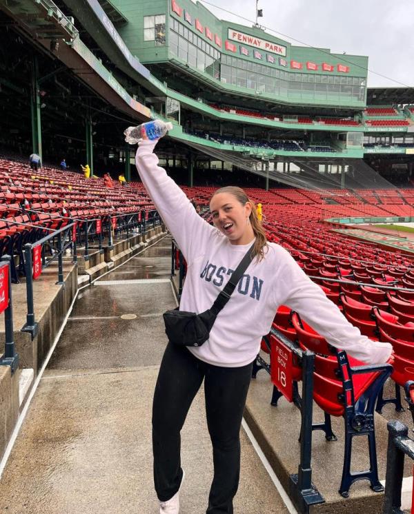 Ali Berke, a young pop singer, holding a water bottle in front of a ba<em></em>seball stadium, preparing to perform the natio<em></em>nal anthem