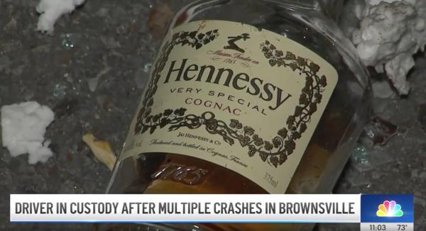 A bottle of Hennessy is strewn across the ground