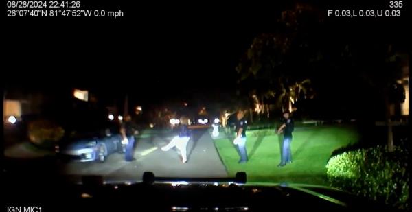 Intoxicated Teresa Heitmann, the mayor of Naples, Florida, struggling to maintain her balance, surrounded by police on a lit road